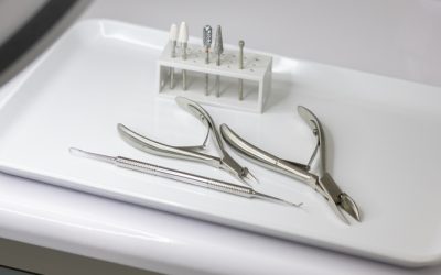 Sterile pedicure and manicure tools in close-up and a lamp with a magnifying glass. Pliers, pliers, pedicure curette